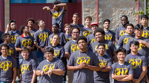 A cohort of Men of Distinction students pose wearing matching t-shirts